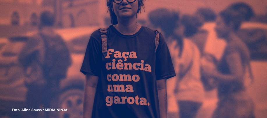Imagem alaranjada destacando garota com mochilas nas costas vestindo uma camisa com a seguinte frase "faça ciência como uma garota". Há meninas circulando atrás da da garota com a camiseta..